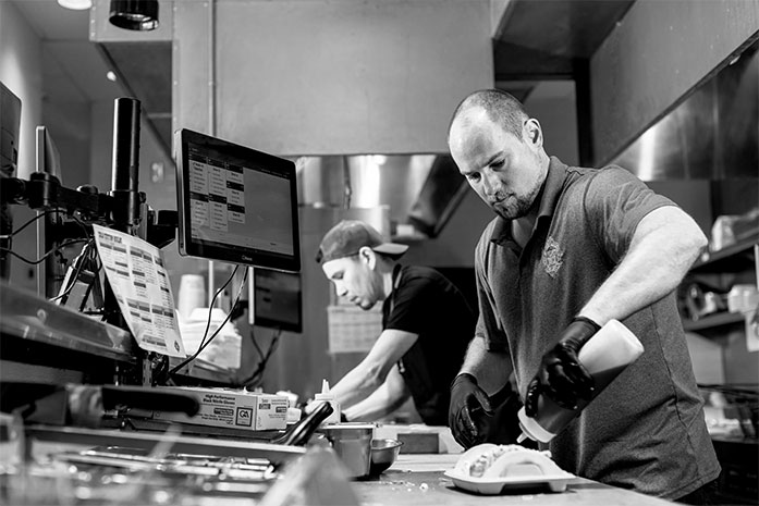 Black and white image of Velvet Taco team members in the kitchen